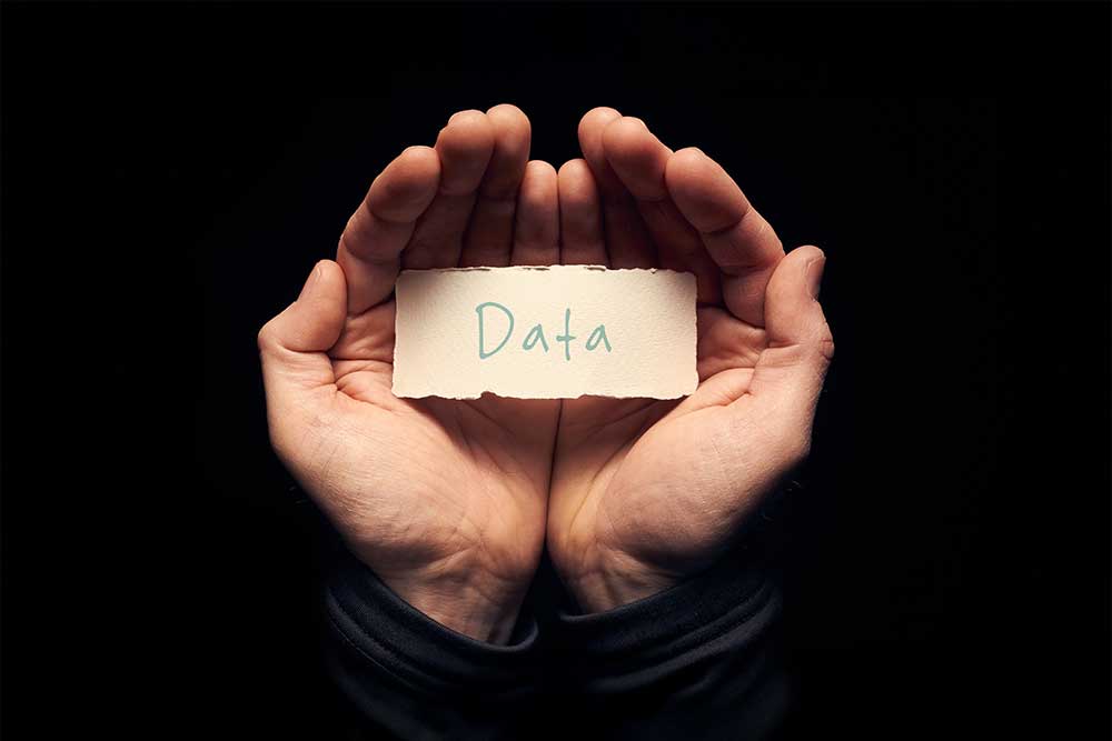 Data written on a post it held by hands concept