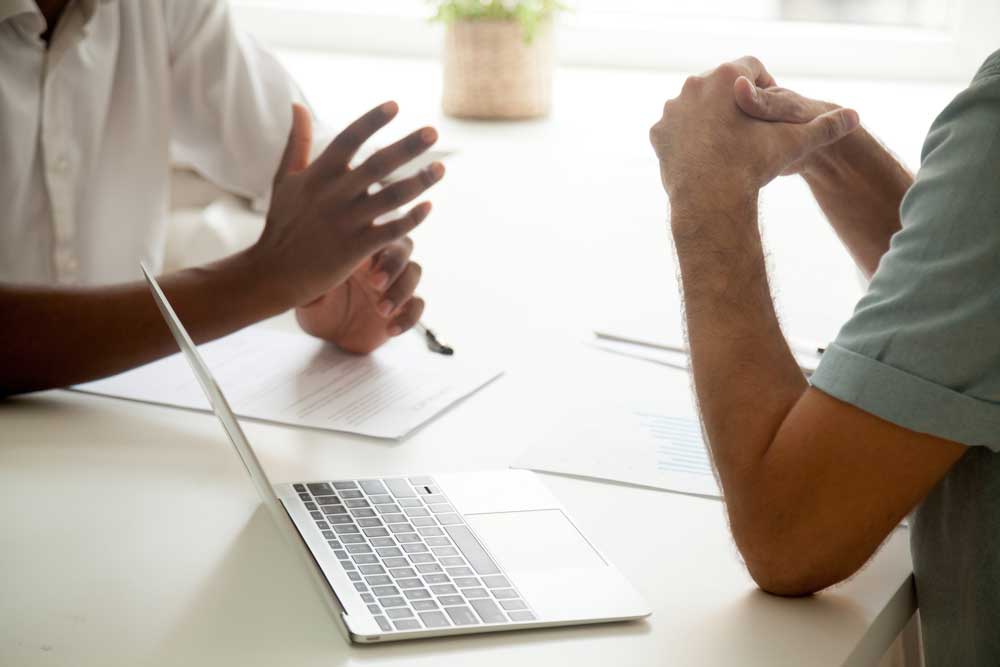 Close up of colleagues gesturing while talking at business meeting