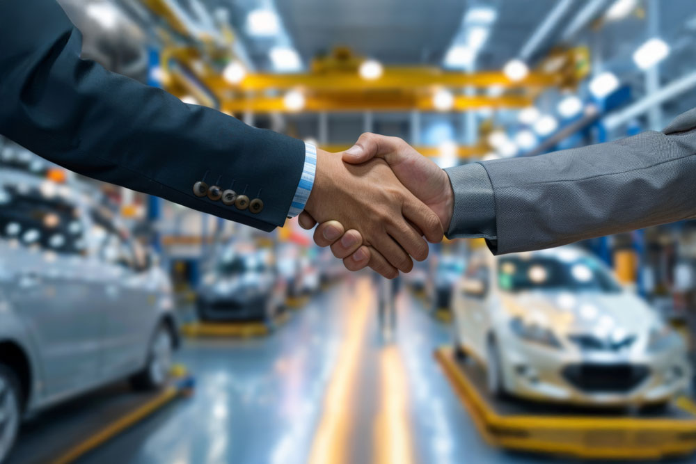Two men shaking hands dressed in suit in car dealer shop