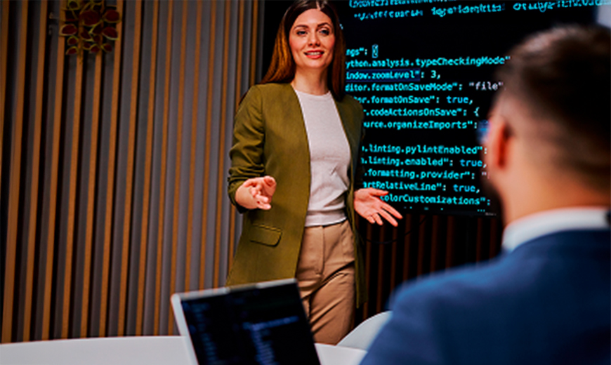 Tech lead presenting code on a large screen during a meeting with engineering and data teams