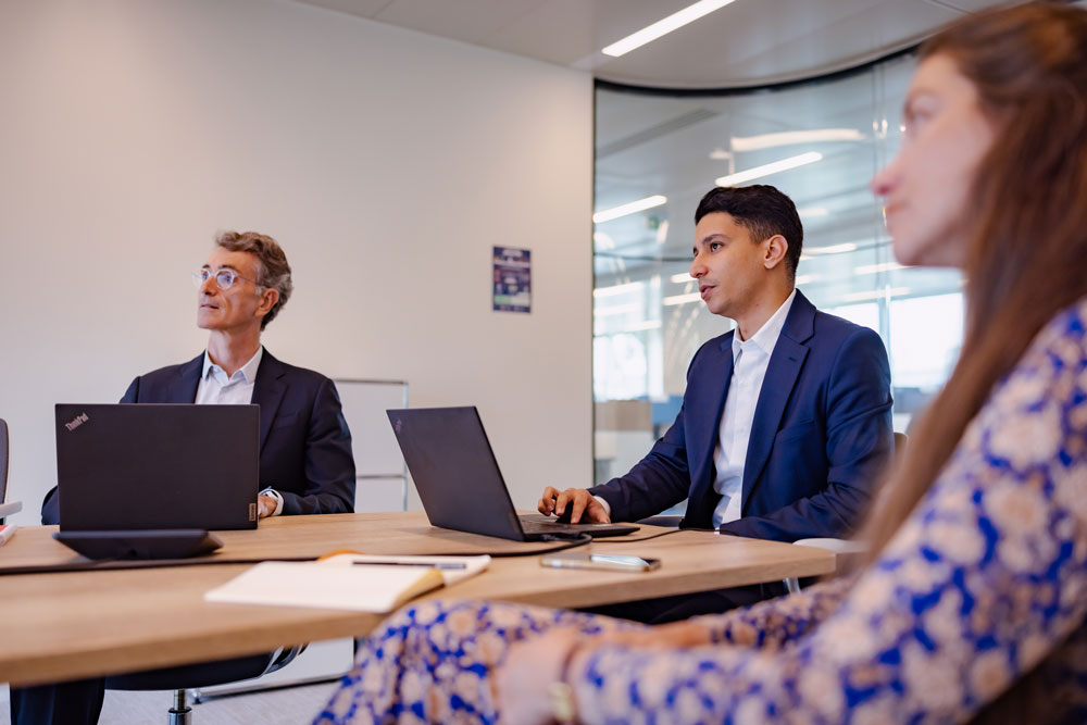 SCOR team in a risk business meeting, analyzing a strategic presentation related to reinsurance and data