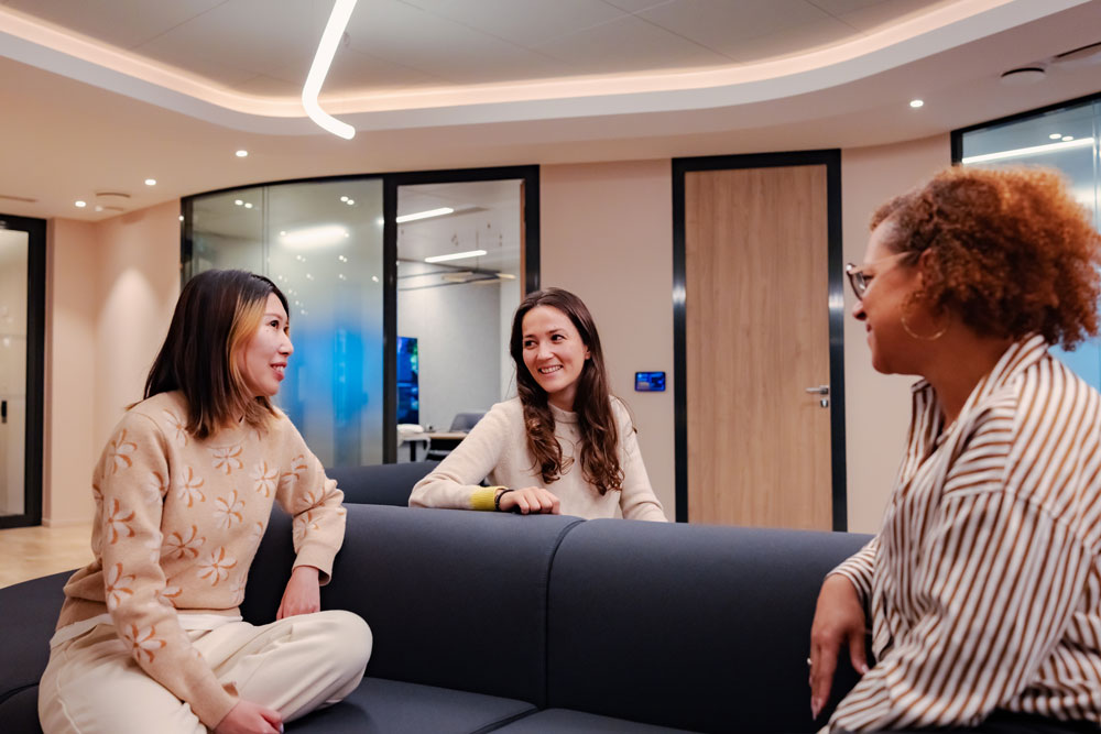 SCOR employees engaged in informal conversation in a relaxation area, reflecting the company's collaborative and innovative culture
