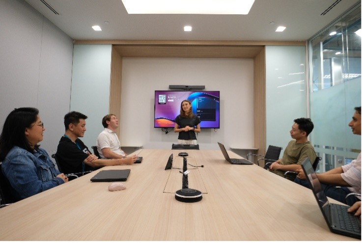 SCOR employees gathered around a presentation in a large meeting room