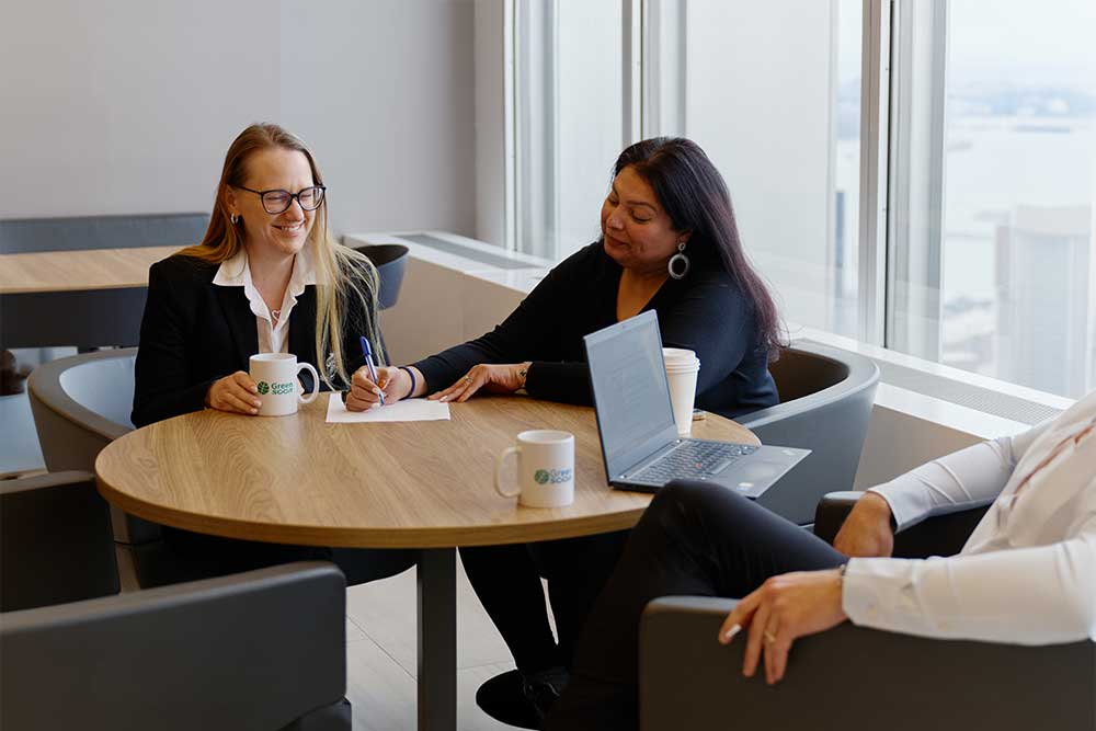 SCOR employees chatting informally in a modern office space, illustrating the company's friendly atmosphere and expertise in reinsurance