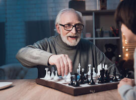 man playing chess with his grandson