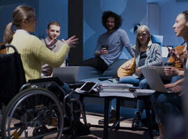 Handicapped young woman with colleagues working in office. 