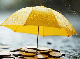 Yellow umbrella covering coins in the rain