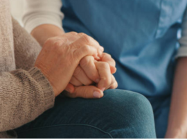 Image of a carer holding an elderly person's hand