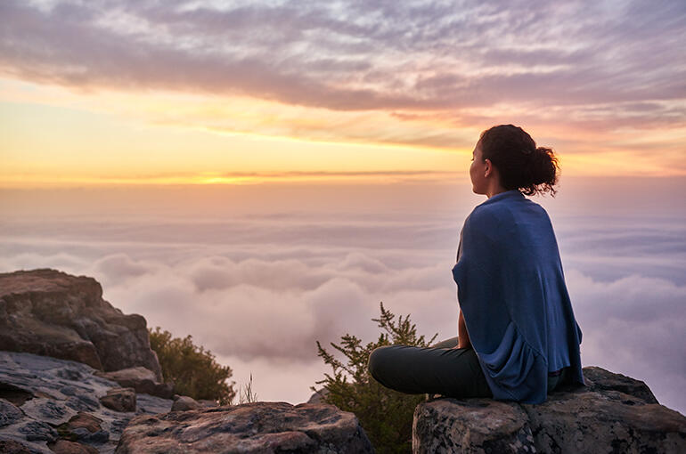 A woman looking at a quiet mountain landscape