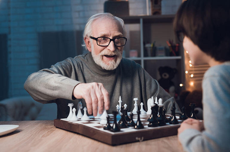 man playing chess with his grandson