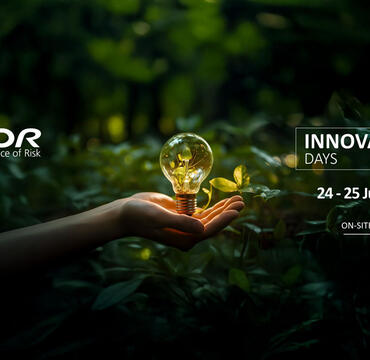 Hand surrounded by leaves holding a light bulb filled