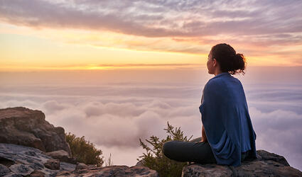 A woman looking at a quiet mountain landscape