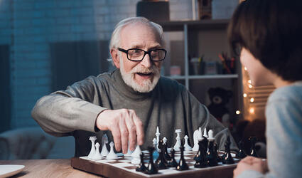 man playing chess with his grandson