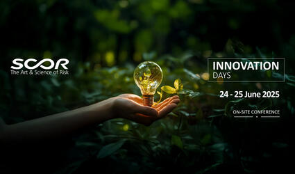 Hand surrounded by leaves holding a light bulb filled