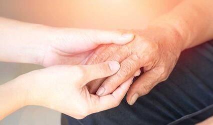 SCOR SCORacle Newsletter Parkinson’s Disease teasr image with a medical person holding an old patient's hand